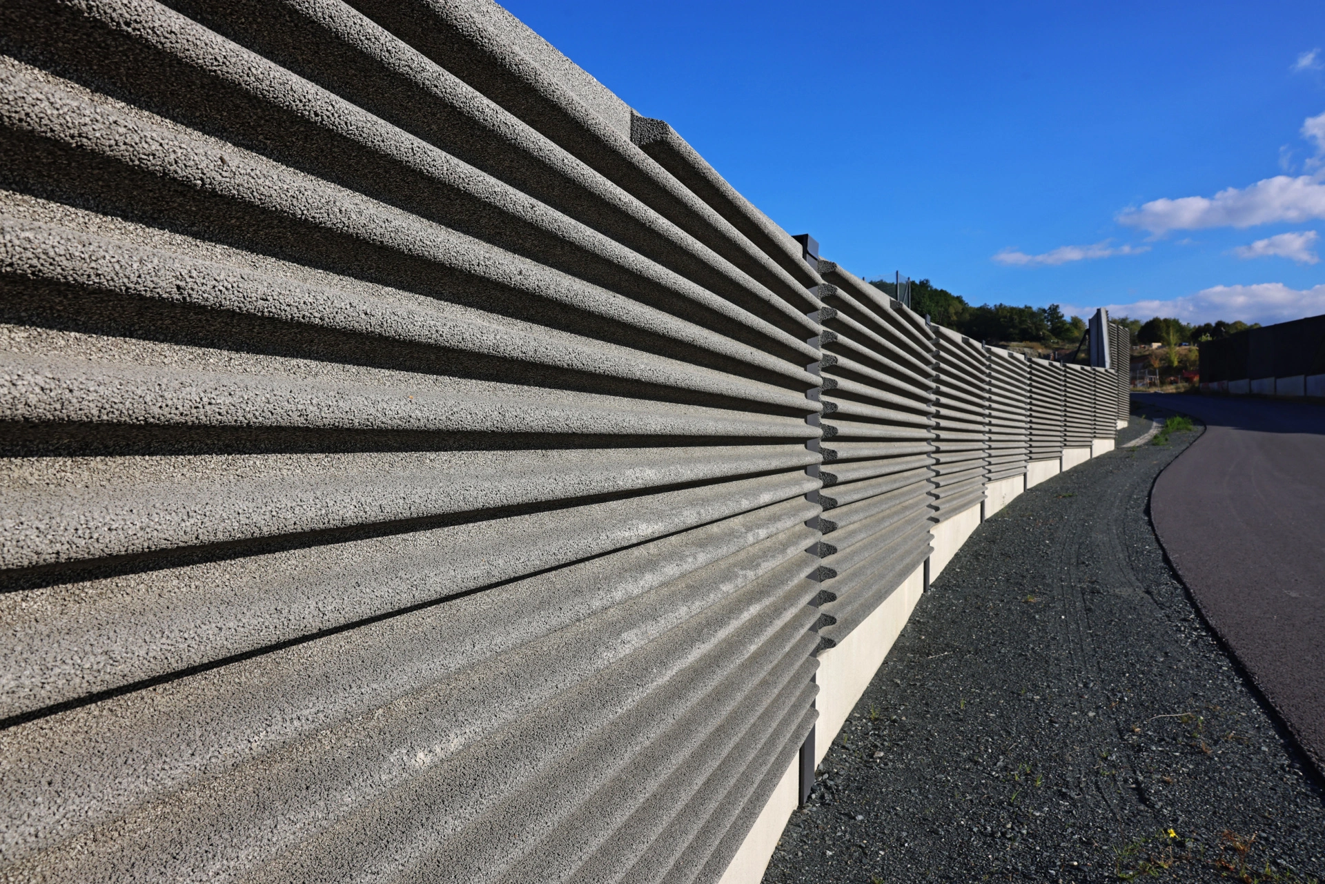 Die geforderten Gestaltungselemente in Form horizontaler Wellen auf den Lärmschutzwänden wurden in Absorptionsbeton realisiert.